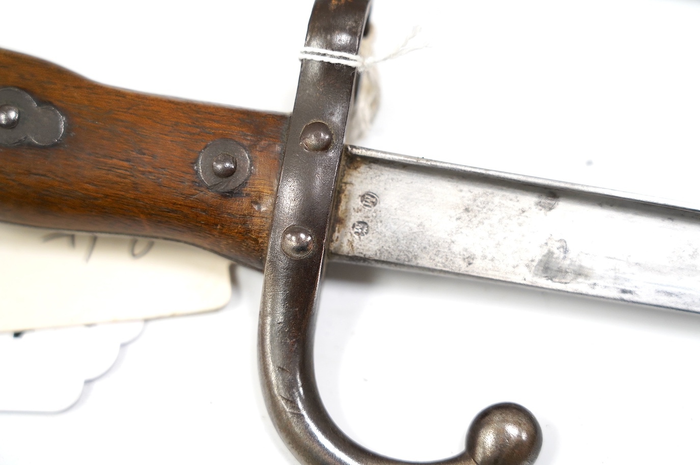 An 1875 French T-section bayonet in its steel scabbard for a Gras rifle, with engraving in French to the top of the blade. Condition - good